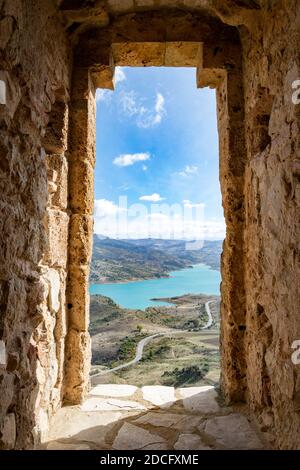 une vue à travers une fenêtre en pierre depuis les ruines du château De Zahara de la Sierra Banque D'Images