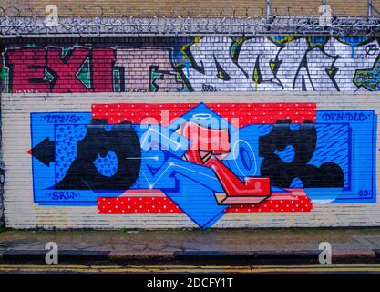 Graffiti bleu vif, rouge et noir par décor, sur les murs de Gray Eagle Street, Shoreditch, East London, Royaume-Uni Banque D'Images