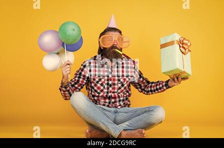 tout pour moi. amusez-vous en fête. préparez-vous pour les vacances. Event Manager pose avec un accessoire festif. Concept amusant et heureux. Homme heureux tenant des ballons d'hélium colorés. hipster souriant joyeusement. Banque D'Images