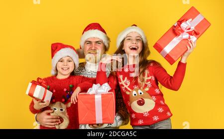 Cadeaux pour tout le monde. Noël devient spécial avec les enfants. Concept de la veille de Noël. Shopping en famille. Soldes de Noël. Papa, les enfants s'amusent. Le père et les petites filles célèbrent ensemble la nouvelle année. Banque D'Images