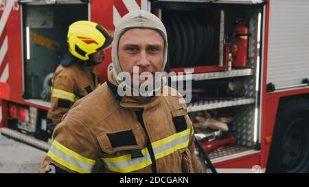 Deux pompiers debout devant le camion d'incendie. Exercice d'incendie . Photo de haute qualité Banque D'Images