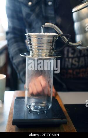 Grande-Bretagne / Angleterre / Londres / Coffee style /Barista prépare un café filtre avec un brasseur à vagues Kalita. Banque D'Images