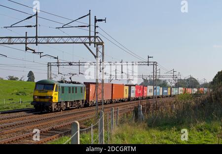 Une locomotive électrique de classe 90 numéro 90046 qui travaille un freightliner bien chargé à Old Linslade sur la ligne principale de la côte ouest. Banque D'Images