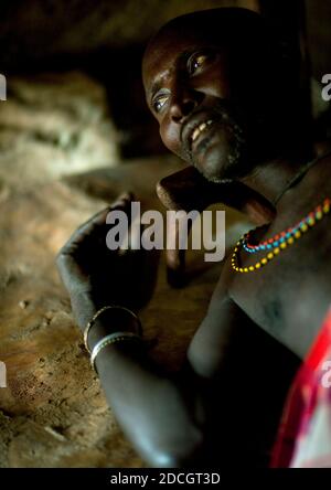 Portrait d'un guerrier de tribu Samburu reposant sur son lit, comté de Samburu, Maralal, Kenya Banque D'Images