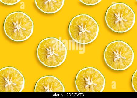 Motif d'été branché au soleil avec une tranche de citron jaune doux sur fond jaune clair. Banque D'Images