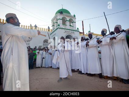 Des hommes musulmans chantant et dansant avec des bâtons de goma pendant le festival Maulid, comté de Lamu, Lamu, Kenya Banque D'Images