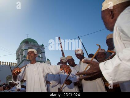 Des hommes musulmans chantant et dansant avec des bâtons de goma pendant le festival Maulid, comté de Lamu, Lamu, Kenya Banque D'Images