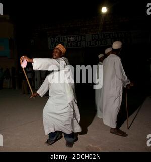 Des hommes musulmans chantant et dansant avec des bâtons de goma pendant le festival Maulid, comté de Lamu, Lamu, Kenya Banque D'Images