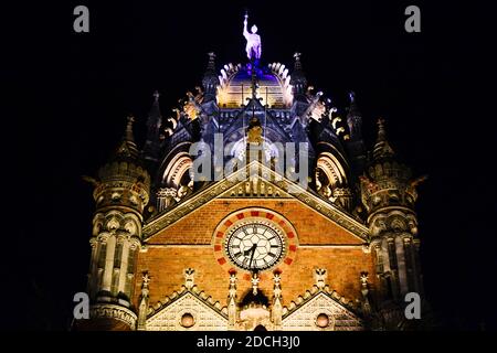 Chhatrapati Shivaji Terminus CST la nuit. Bâtiment central éclairé du Victoria Terminus avec statue et horloge illuminée. Mumbai, Inde Banque D'Images