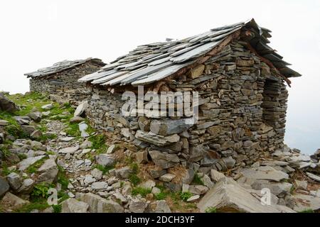 Maisons rocheuses faites pour des abris dans les montagnes pour bergers. Triund Hill, chaîne de montagnes de l'Himalaya, Himachal, Pradesh, Inde Banque D'Images