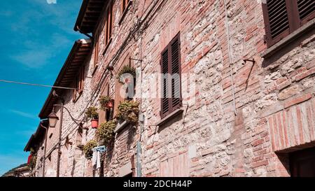 Une maison médiévale en pierre dans un village italien avec des fenêtres en bois, des plantes et des fleurs (Gubbio, Italie, Europe) Banque D'Images