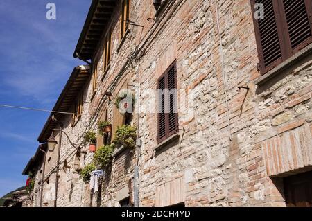 Une maison médiévale en pierre dans un village italien avec des fenêtres en bois, des plantes et des fleurs (Gubbio, Italie, Europe) Banque D'Images