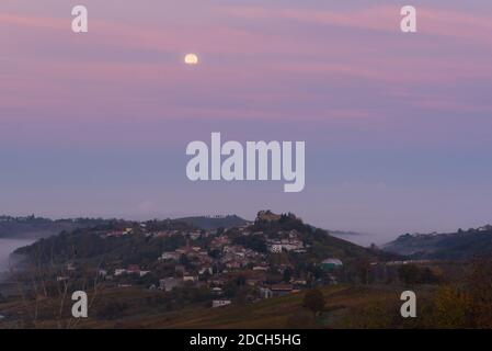 Pleine lune et nuages roses au-dessus de Mornico Losana dans oltrepo pavese en automne Banque D'Images