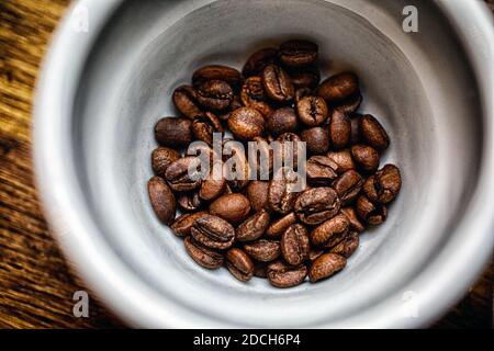 Les grains de café torréfiés tasse en plus de surface en bois Banque D'Images