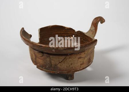 Pot de cuisine, Anonyme, XVIIIe siècle, glaçure de plomb, faïence, général : 10 x 22.7 x 17,5 cm 100 x 227 x 175 mm, pot de cuisson avec poignée en faïence rouge, recouvert à l'intérieur de glaçure de plomb. Le pot a un corps cylindrique avec un fond plat et se tient sur trois pieds. Le bord large de la bouche est incliné vers l'extérieur. Composé de éclats. Environ la moitié du bord de la bouche est manquante et trois éclats sont manquants sur le mur et le fond, 1987 Banque D'Images