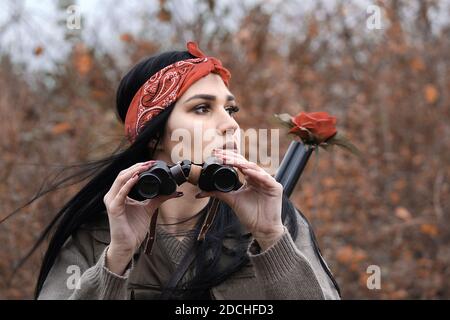 Une belle fille chasseur tenant des jumelles Banque D'Images