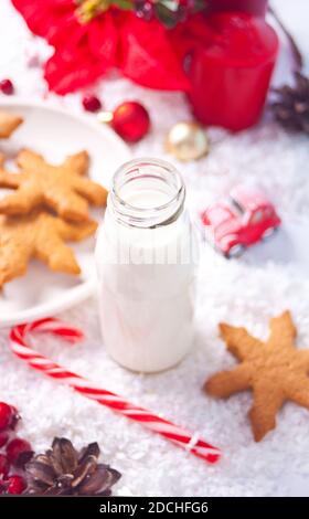 Biscuits, canne à sucre et lait pour le Père Noël sur la table sur le fond de décoration de Noël. Banque D'Images