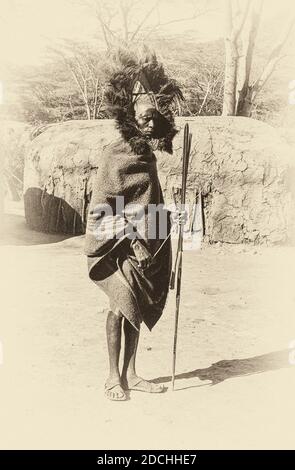 Kenya. C'est un chef aîné de Maasai au rassemblement annuel des populations tribales de Maasai dans la vallée du Rift non loin de la petite ville de Narok, Lorsque les jeunes Maasai Moran se défilent et dansent dans l'un des villages dans l'espoir d'attirer quelques jeunes filles en tant que future femme. La lance est purement cérémoniale, tout comme sa robe de tête des plumes d'Ostrich. Il offre également l'occasion aux femmes d'afficher et, espérons-le, de vendre une partie de leurs œuvres d'art distinctives. La maison ancestrale de Maasai est la vallée du Rift qui forme le célèbre parc national et réserve de gibier de Maasai Mara. Banque D'Images