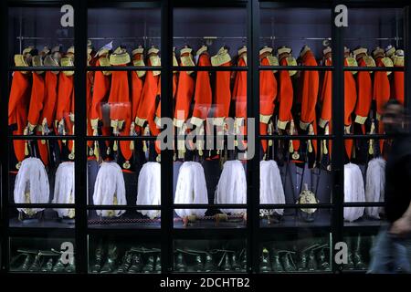 Armoire de Gits & Hawkes contenant une rangée d'uniformes de écarlate, ornée de glands dorés et d'aiguilettes tressées en corde. Banque D'Images