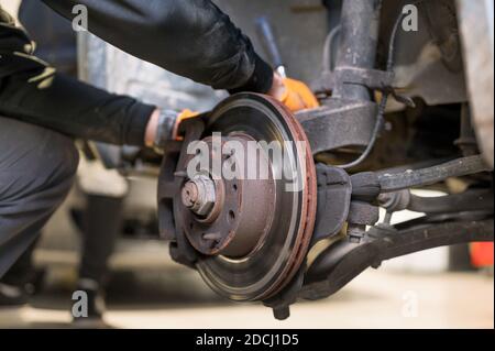 Gros plan sur les plaquettes de frein de réparation par un mécanicien automobile. Photo de haute qualité Banque D'Images