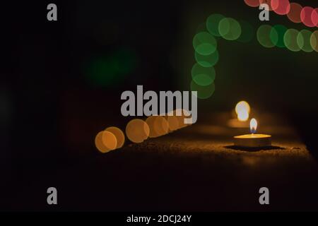 de belles bougies allumées pendant la fête de noël sont rangées. cercles bokeh colorés en arrière-plan. prises de nuit avec une faible profondeur de f Banque D'Images