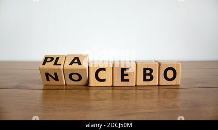 Nocebo ou placebo. Les cubes tournaient et changeaient le mot « placebo » en « nocebo », ou vice versa. Belle table en bois, fond blanc, espace de copie. Medic Banque D'Images