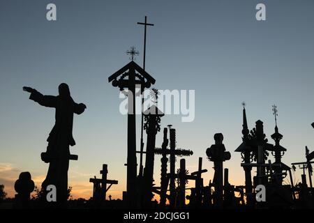 Croix en bois sur la colline des croix près de Šiauliai en Lituanie, photographiée au coucher du soleil. Le plus important site de pèlerinage lituanien est situé à environ 12 km de la ville de Šiauliai. Personne n'a jamais essayé de compter combien de grandes et petites croix sont effectivement installées sur la colline, mais on croit qu'il y a au moins deux cent mille croix ici. Et chaque jour, des dizaines, voire des centaines de nouvelles croix, sont ajoutées par des pèlerins du monde entier. Banque D'Images