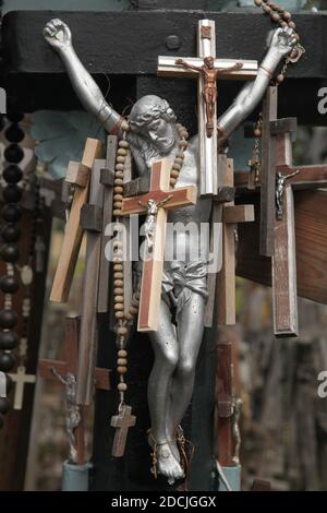 Figure de Jésus-Christ sur le crucifix décoré de petites croix en bois sur la colline des croix près de Šiauliai en Lituanie. Le plus important site de pèlerinage lituanien est situé à environ 12 km de la ville de Šiauliai. Personne n'a jamais essayé de compter combien de grandes et petites croix sont effectivement installées sur la colline, mais on croit qu'il y a au moins deux cent mille croix ici. Et chaque jour, des dizaines, voire des centaines de nouvelles croix, sont ajoutées par des pèlerins du monde entier. Banque D'Images