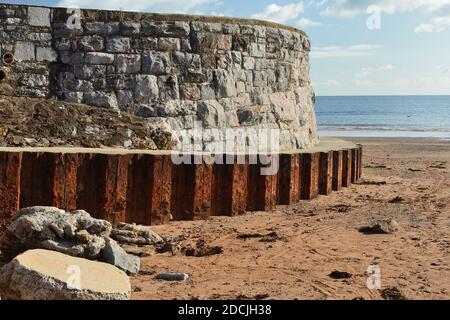 Une section courbée de digue avec des fondations en béton prolongées. Banque D'Images