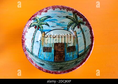 Le Caire, novembre 10.A UN style nubien peint fait à la main coupe de poterie égyptienne montre une maison nubienne entre deux palmiers sur fond jaune. Banque D'Images