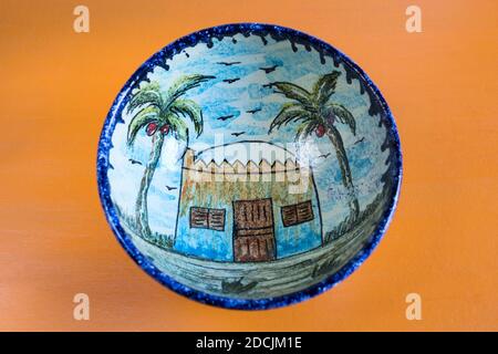 airo, novembre 10.Nubian style fait à la main art peint coloré poterie décorée montre une maison nubienne entre deux palmiers sur fond jaune. Banque D'Images