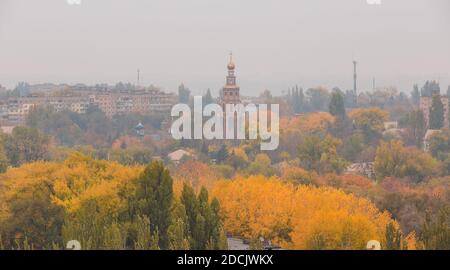 Magnifique paysage d'automne avec clocher sur fond ciel gris. Arbres dorés. Banque D'Images