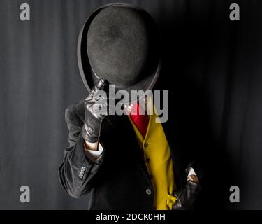 Portrait d'un homme bien habillé en gilet jaune vif et chapeau de style bowling à motif Red Tie. Concept de gentleman anglais classique. Banque D'Images