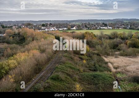 Une ligne de chemin de fer à voie unique circule sur un remblai surcultivé entre le chemin de fer Portishead et le quai Royal Portbury Dock à Pill dans le nord du Somerset. Banque D'Images