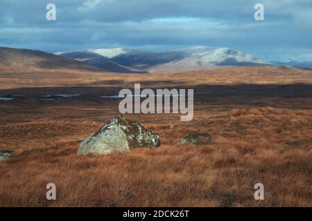 Une grande pierre sur un plateau de haute montagne sur un fond de sommets enneigés. Paysage pittoresque en automne. Vue de la route de Glencoe. Highland, Écosse Banque D'Images