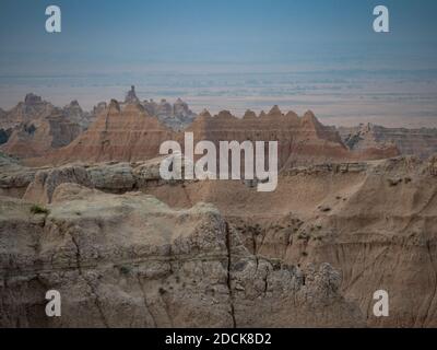 Vue sur la section des Pinnacles du parc national des Badlands dans le Dakota du Sud. Les montagnes accidentées sont baguées. Ciel voilé au-dessus. Banque D'Images