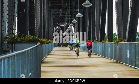 Little Rock, AR--le 22 mai 2018; les cyclistes traversent le pont piétonnier William Jefferson Clinton au centre-ville en face de North Little Roc Banque D'Images