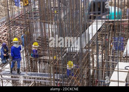 Les ouvriers de la construction fabriquent de grandes barres de renfort en acier sur le chantier de construction de la zone de construction. Banque D'Images