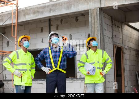 Contrôle des ouvriers de construction d'équipe asiatique dans la structure de la maison à chantier Banque D'Images