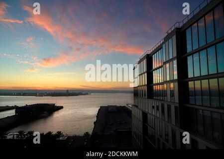 San Diego, Californie, États-Unis. 19 novembre 2020. Le soleil se couche sur la baie de San Diego et se reflète dans les fenêtres d'un hôtel SpringHill Suites by Marriott. Le tourisme, l'une des principales industries de San Diego, a été touché par le ralentissement des voyages dû à Covid-19. Crédit : K.C. Actualités en direct Alfred/ZUMA Wire/Alay Banque D'Images