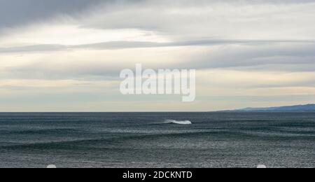 Une grande vague se brisant dans l'océan avec l'espace de copie et ciel bleu et nuageux Banque D'Images