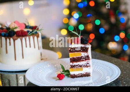 Gâteau de Noël maison aux fruits. Bonne année et joyeux Noël. Décorations d'hiver sur fond sombre avec effet de flou artistique xmas Tree light. Mise au point sélective Banque D'Images