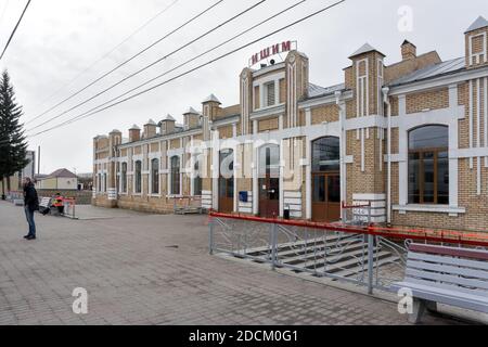 Un homme se tient sur la plate-forme de la gare (construite en 1913) à Ishim, un jour de printemps nuageux. Région de Tyumen. Russie. Banque D'Images