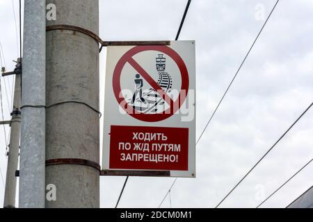 Le panneau d'interdiction est suspendu sur un poteau en béton à la gare de la ville sibérienne de Barabinsk, avec les mots "il est interdit de marcher sur les voies ferrées. Banque D'Images