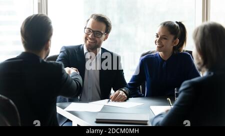 Des hommes d'affaires souriants se bousculer lors d'un briefing d'équipe Banque D'Images