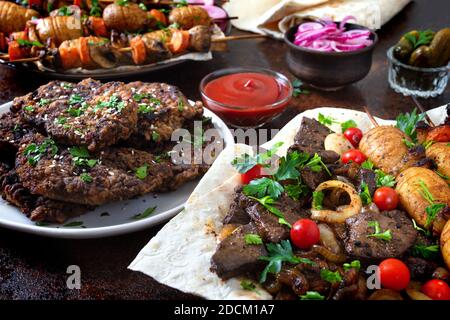 Foie broché, légumes entiers et champignons sur brochettes. Menu du restaurant grill. Cuisine géorgienne et asiatique. Différents plats de kebab de foie. Banque D'Images