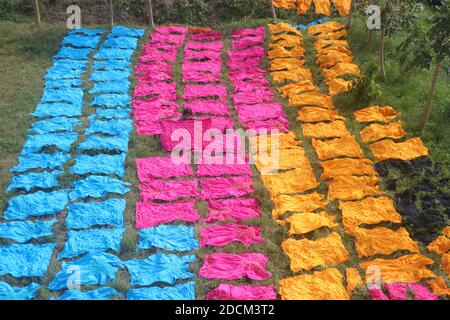 Les travailleurs bangladais collectent des tissus après les avoir séchés sous le soleil dans une usine de teinture à Narayanganj, au Bangladesh. Nazmul Islam/Alamy stock photo Banque D'Images