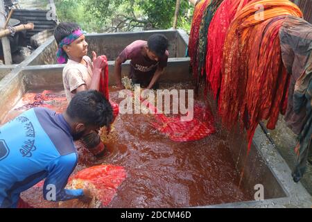 Les travailleurs bangladais collectent des tissus après les avoir séchés sous le soleil dans une usine de teinture à Narayanganj, au Bangladesh. Nazmul Islam/Alamy stock photo Banque D'Images