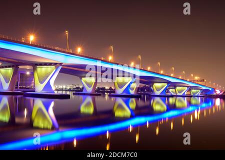5 novembre 2020 Dubai eau. Magnifique vue nocturne d'hiver sur le pont Al Garhoud illuminé par des lumières bleues à Dubaï, eau avec reflets d'eau. Exposition longue Banque D'Images