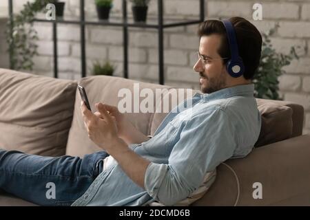 Un jeune homme décontracté écoute de la musique dans un casque. Banque D'Images